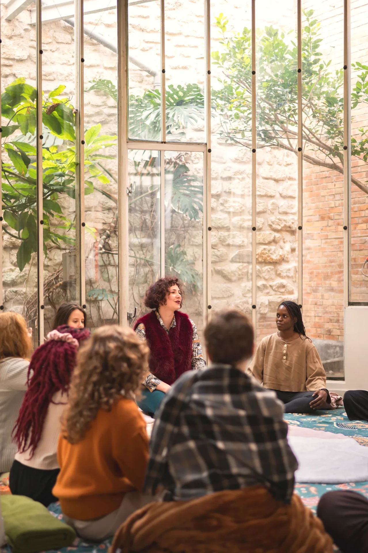 the seated circle, a green plant behind the glass roof